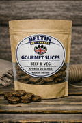 A stand-up kraft paper pouch of Beltin Gourmet Slices Beef & Veg pet treats on a rustic wooden surface, with a few slices placed in front and a burlap sack blurred in the background.